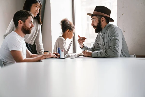 Imagen Colegas Jóvenes Hombres Multiétnicos Discutiendo Ideas Negocios Mesa Mientras — Foto de Stock