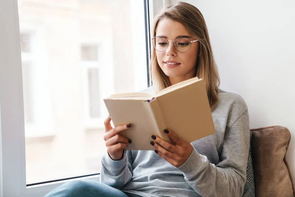 Foto Una Mujer Hermosa Seria Anteojos Leyendo Libro Mientras Está —  Fotos de Stock