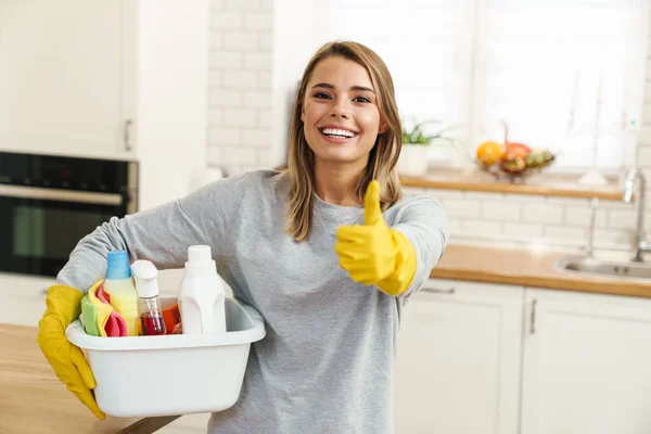 Foto Uma Jovem Dona Casa Sorrindo Luvas Segurando Garrafas Limpador — Fotografia de Stock