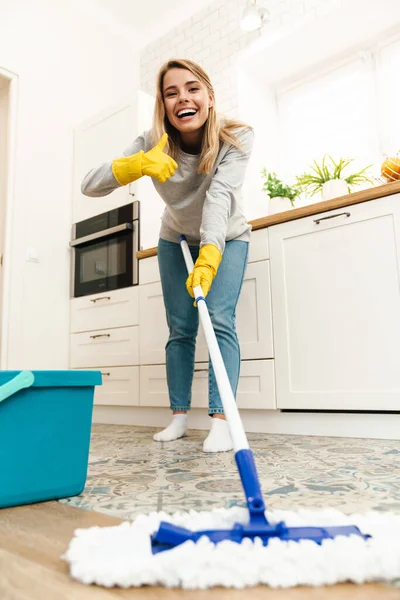 Foto Alegre Joven Ama Casa Con Guantes Señalando Pulgar Hacia — Foto de Stock