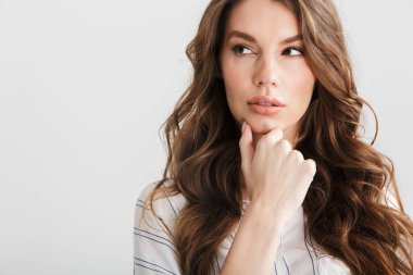 Beyaz arka planda izole edilmiş beyaz kadın pozu veren ve yan bakan beyaz kadın.