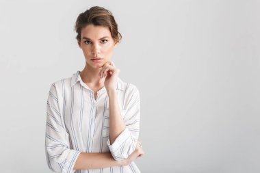 Beyaz arka planda izole edilmiş, poz veren ve kameraya bakan hoşnutsuz beyaz kadın görüntüsü