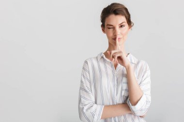 Mutlu bir kadının beyaz arka planda izole edilmiş sessiz bir jest ve göz kırpan görüntüsü.