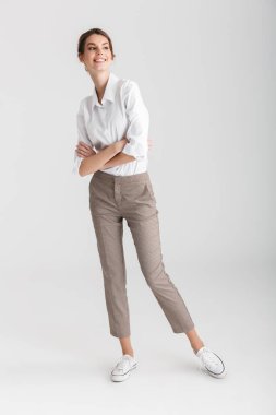 Beyaz arka planda elleri çapraz pozlar veren genç bir kadın görüntüsü izole edilmiş.