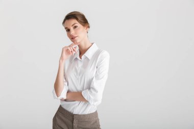 Beyaz arka planda izole edilmiş poz veren ve kameraya bakan baştan çıkarıcı genç bir kadın görüntüsü