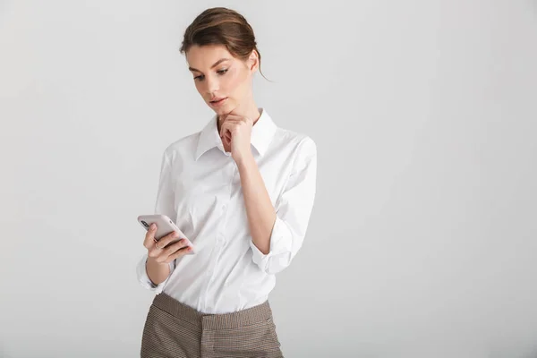Afbeelding Van Ernstige Mooie Vrouw Typen Mobiele Telefoon Geïsoleerd Witte — Stockfoto