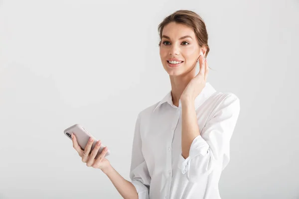 Imagen Una Hermosa Mujer Sonriente Usando Auriculares Inalámbricos Teléfonos Móviles — Foto de Stock