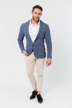 Ceket giyen, gülümseyen ve beyaz arka planda izole edilmiş kameraya bakan neşeli bir genç resmi.