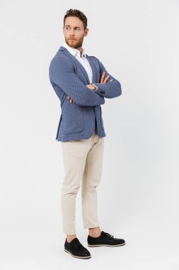 Ceket giyen ciddi bir gencin görüntüsü beyaz arka planda izole edilmiş bir şekilde poz vermesi ve bakması.