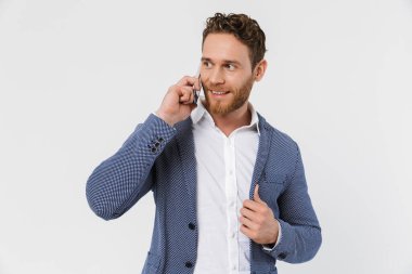 Beyaz arka planda izole edilmiş, gülümseyen ve akıllı telefondan konuşan ceketli yakışıklı bir adam görüntüsü