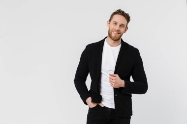 Beyaz arka planda izole edilmiş, gülümseyen ve poz veren ceketli yakışıklı bir adam resmi.