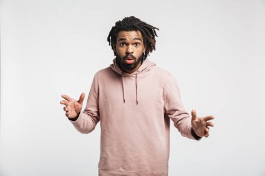 Kafası karışmış, kapüşonlu genç bir adamın portresi beyaz arka planda tek başına duruyor.