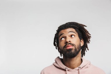 Kapüşonlu genç bir Afrikalı 'nın portresi beyaz arka planda tek başına dikiliyor, başka tarafa bakıyor.