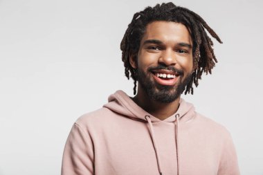 Beyaz arka planda tek başına kameraya bakarak duran kapüşonlu, gülümseyen Afrikalı genç bir adamın portresini yakından çek.