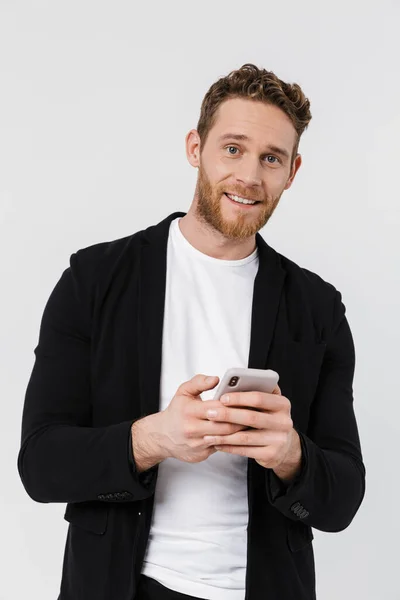 Image Handsome Joyful Man Jacket Smiling Using Smartphone Isolated White — Stock Photo, Image
