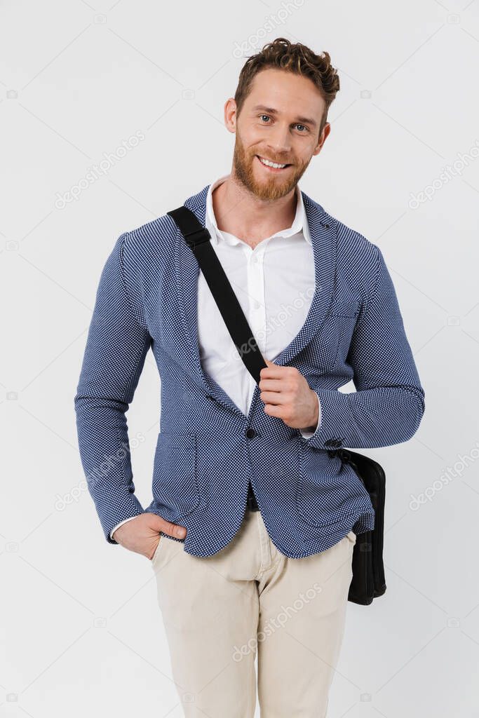Image of smiling young man in jacket posing on camera with bag isolated over white background