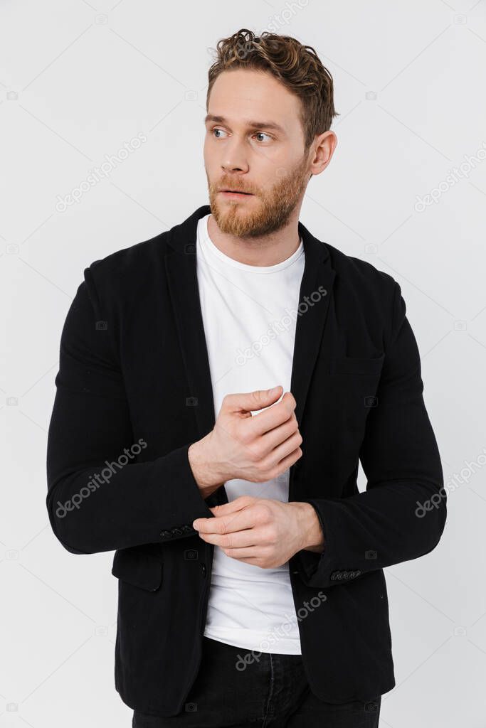 Image of unshaven serious man in jacket posing and looking aside isolated over white background
