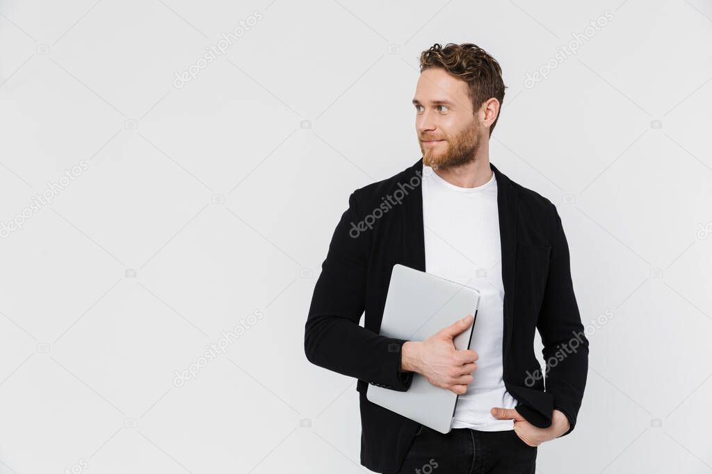Image of handsome pleased man in jacket smiling and holding laptop isolated over white background