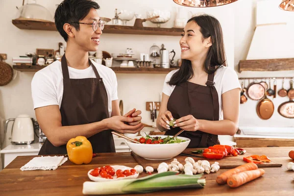 부엌에서 저녁을 요리하면서 당신을 바라보는 문화적 부부의 — 스톡 사진