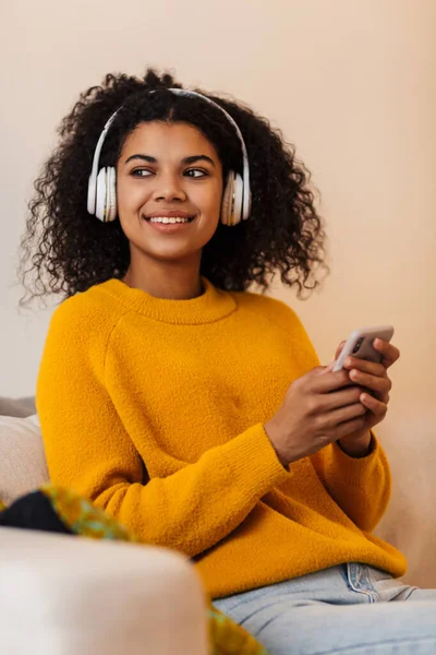 Imagen Alegre Mujer Afroamericana Usando Auriculares Teléfonos Celulares Mientras Está —  Fotos de Stock