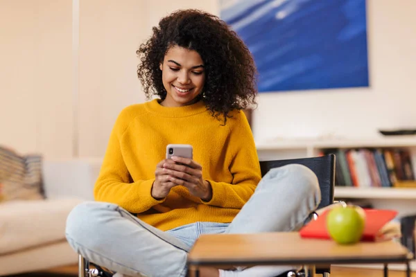 Imagem Uma Mulher Afro Americana Sorrindo Usando Celular Enquanto Senta — Fotografia de Stock