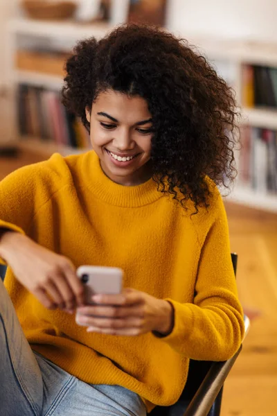 Imagem Uma Mulher Afro Americana Sorrindo Usando Celular Enquanto Senta — Fotografia de Stock