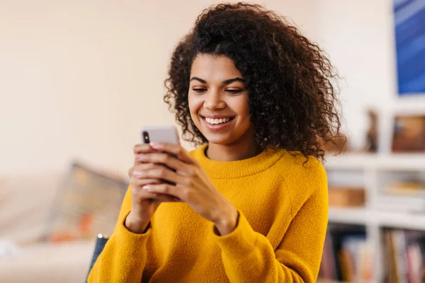 Imagem Uma Mulher Afro Americana Sorrindo Usando Celular Enquanto Senta — Fotografia de Stock