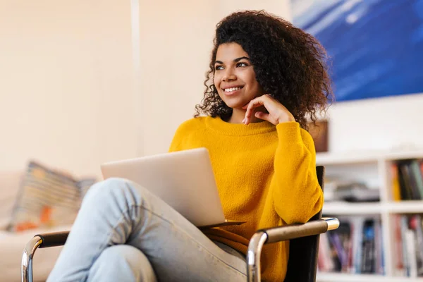 Imagen Una Alegre Mujer Afroamericana Usando Portátil Mientras Está Sentada — Foto de Stock