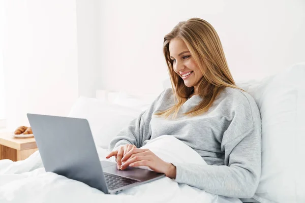 Imagem Mulher Alegre Bonito Sorrindo Usando Laptop Enquanto Deitado Após — Fotografia de Stock