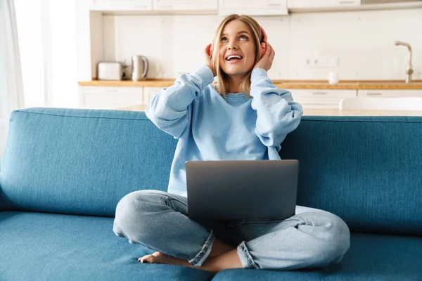 Imagen Una Linda Mujer Sonriente Usando Portátil Auriculares Inalámbricos Mientras —  Fotos de Stock