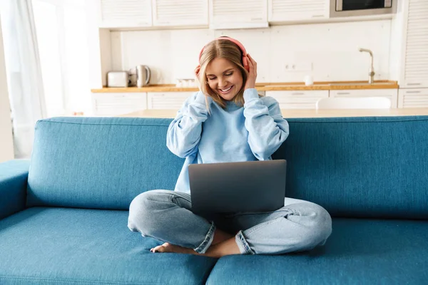 Imagen Una Linda Mujer Sonriente Usando Portátil Auriculares Inalámbricos Mientras —  Fotos de Stock