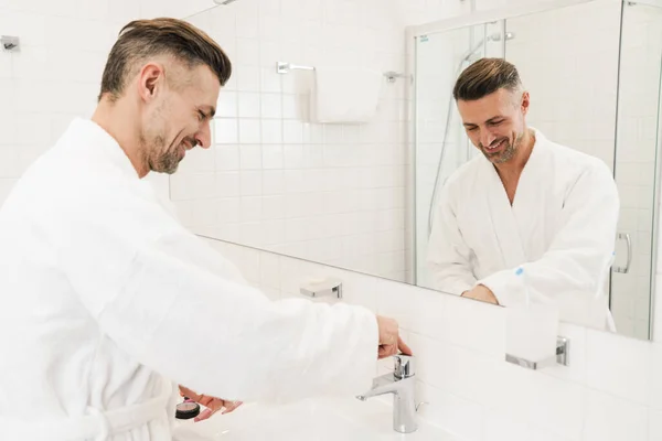 バスルームで洗濯や笑顔白いバスローブを着た陽気な白人男性の写真 — ストック写真