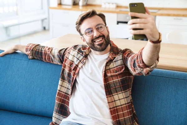 Portrait Young Happy Bearded Man Smiling Using Cellphone While Sitting — Stock Photo, Image