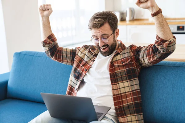 Porträtt Ung Glad Skäggig Man Ler Och Använder Laptop När — Stockfoto