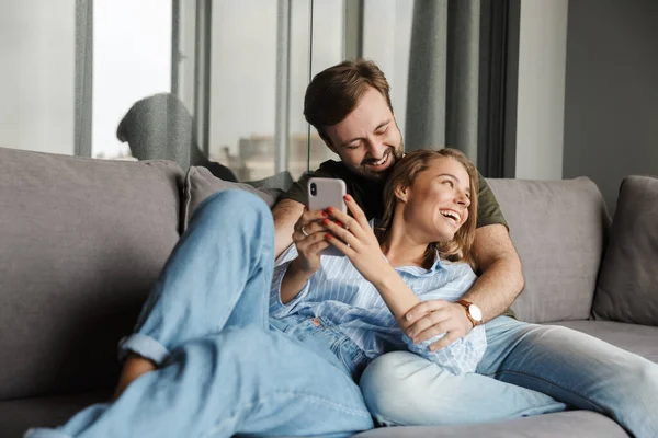 Foto Divertida Pareja Hermosa Agradable Riendo Usando Teléfono Móvil Mientras — Foto de Stock