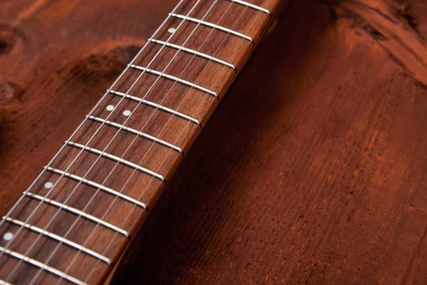 Guitar fretboard on the wooden background — Stock Photo, Image