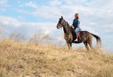 Bir sır küpü üzerinde kot takım elbiseli bir genç kız.
