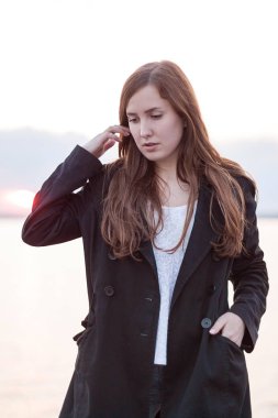 Gün batımında siyah montlu kız