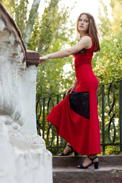 Młoda dziewczyna w długą czerwona sukienka, chodzenie po schodach — Zdjęcie stockowe
