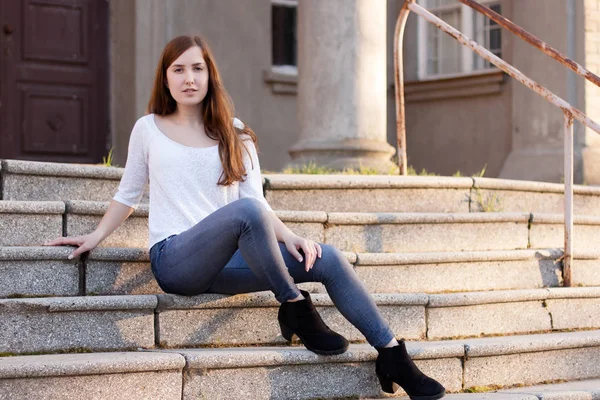 Chica joven sentada en las escaleras — Foto de stock gratis