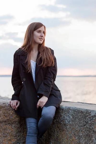 Fille assise près de la rivière — Photo