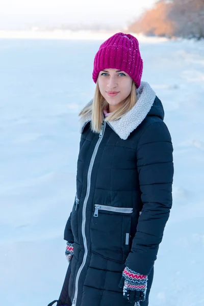 Portret van een jong meisje in roze muts en sjaal in de winter fores — Stockfoto