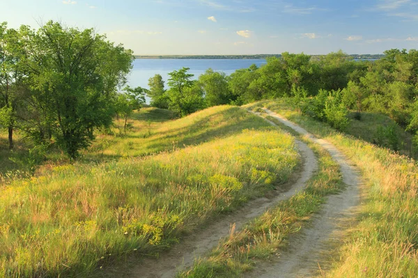 Camino de tierra en las colinas cerca del río — Foto de stock gratis