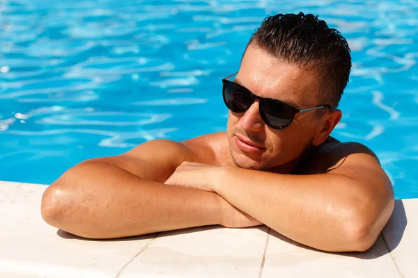 Gros plan portrait de jeune homme séduisant en lunettes de soleil au repos — Photo