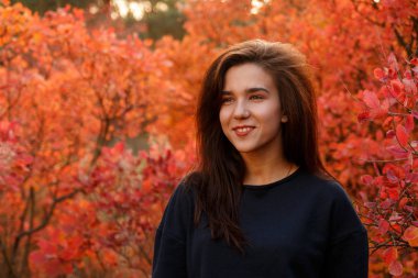 Genç kız spor giyim sonbahar ormanda ayakta