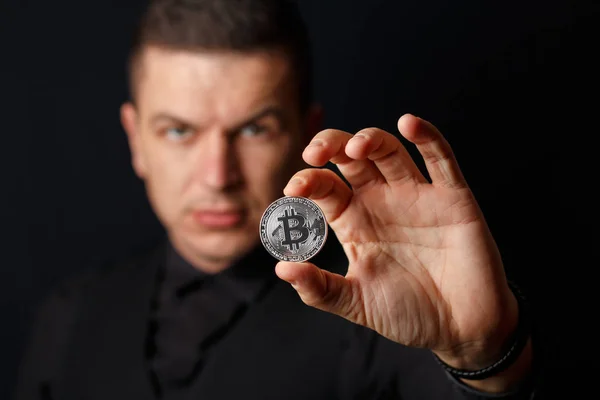 El hombre está sosteniendo bitcoins sobre fondo oscuro —  Fotos de Stock