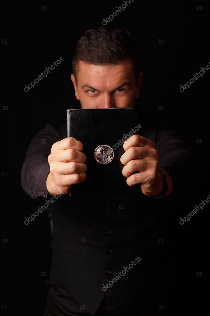 Male holding a book with Bitcoin logo