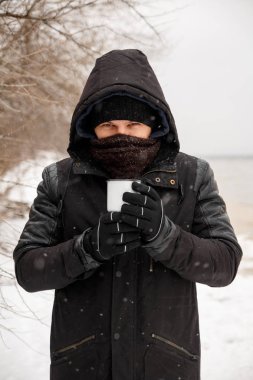 Genç adam bir kış ormanında tutarak.
