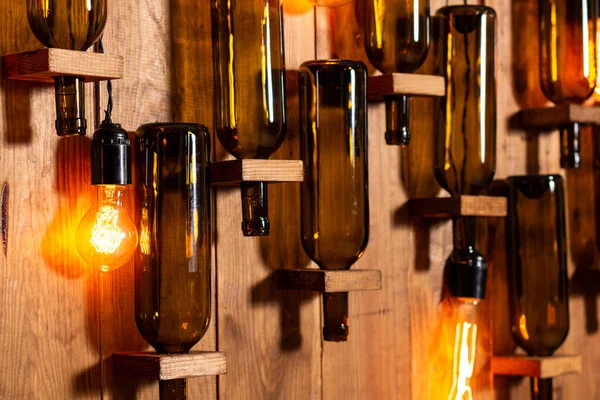 Mur en bois avec bouteilles de vin vides et lampes à incandescence . — Photo