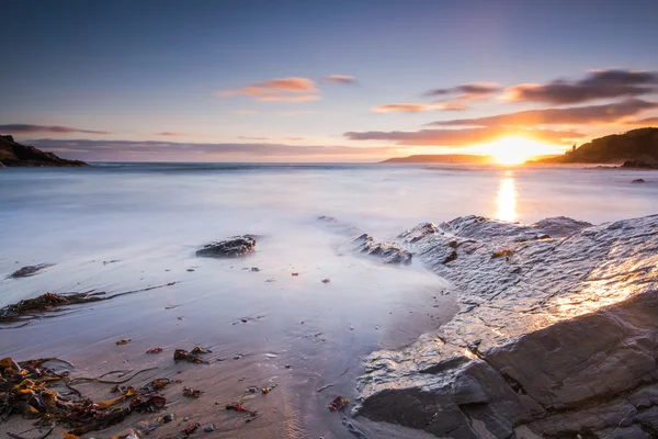 Rust bij zonsondergang op het strand — Stockfoto